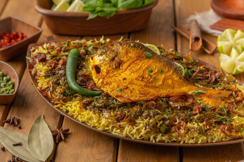 Kuwaiti mutabbaq zubaidi with a whole fried fish over spiced rice